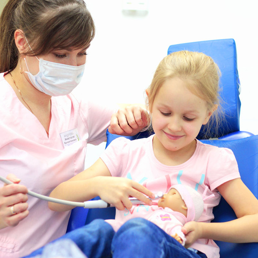 Врач рассказывает девочке о том, для чего нужны стоматологические инструменты